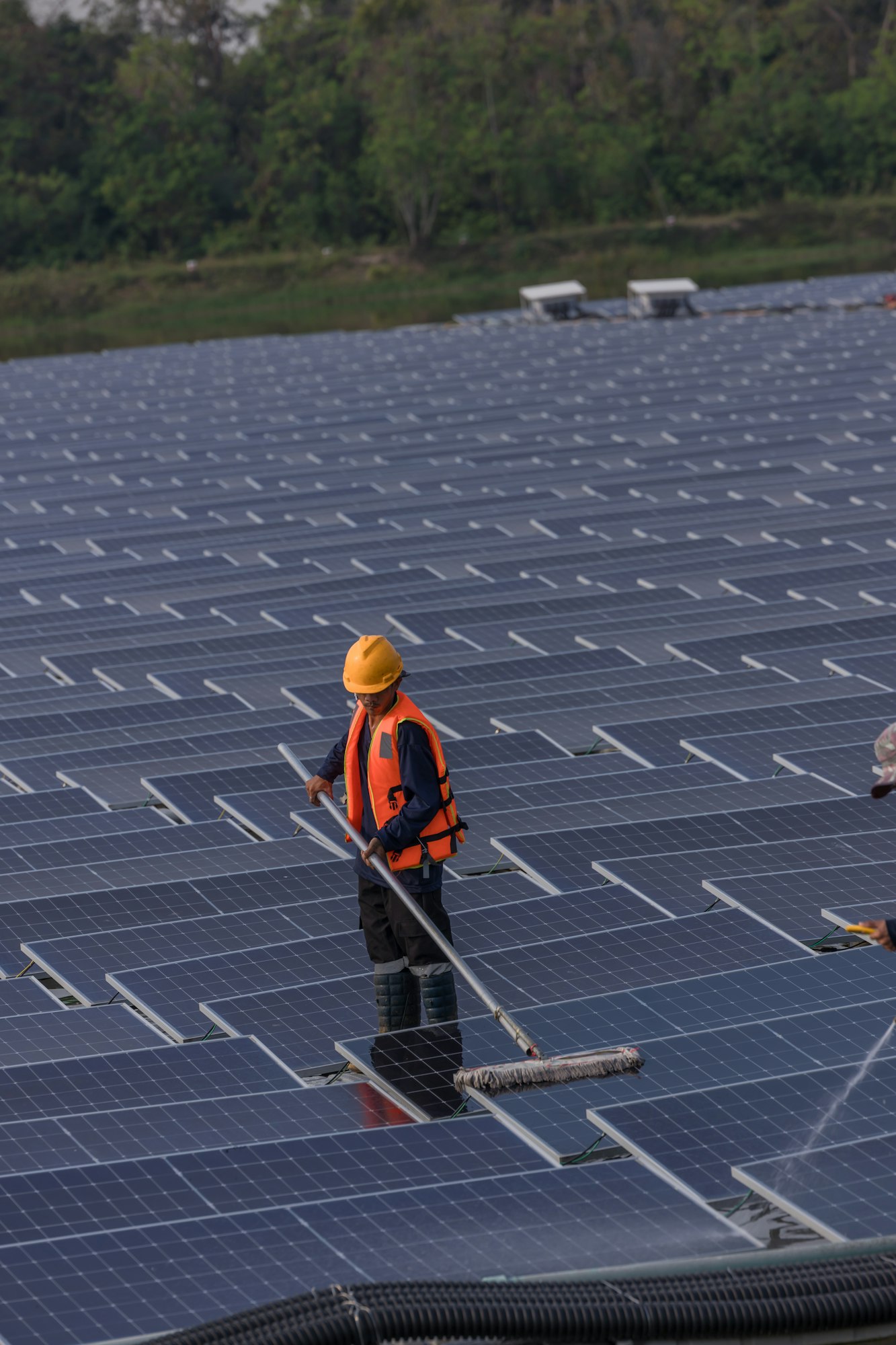 Worker Cleaning floating solar panels or solar cell Platform system on the lake